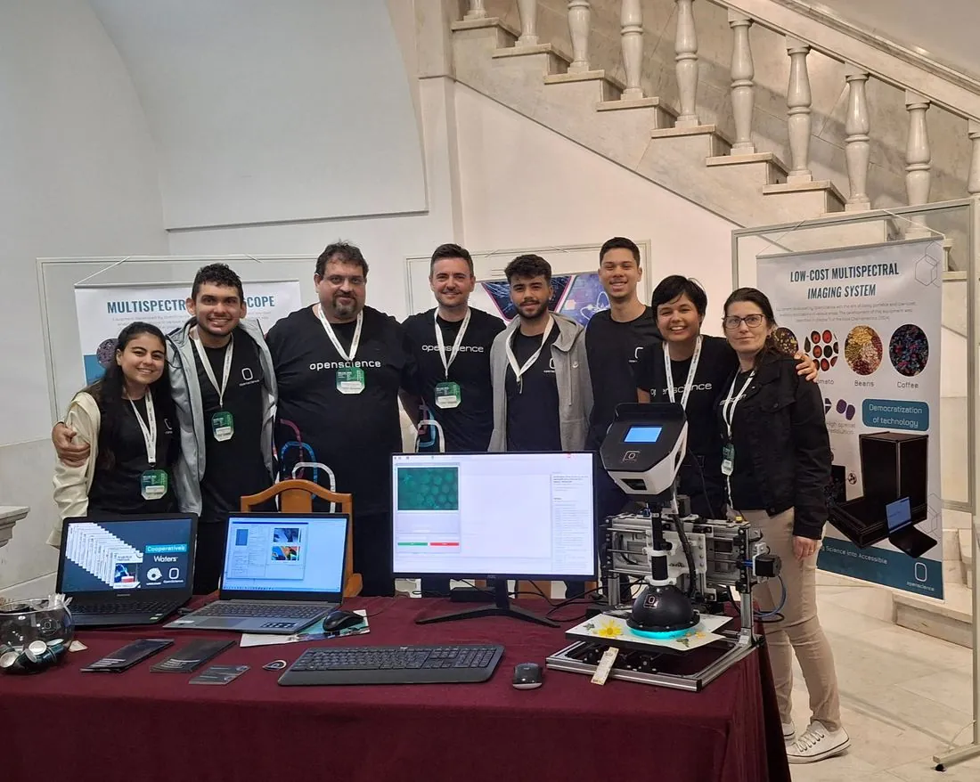 Equipe no estande, com o microscópio multiespectral